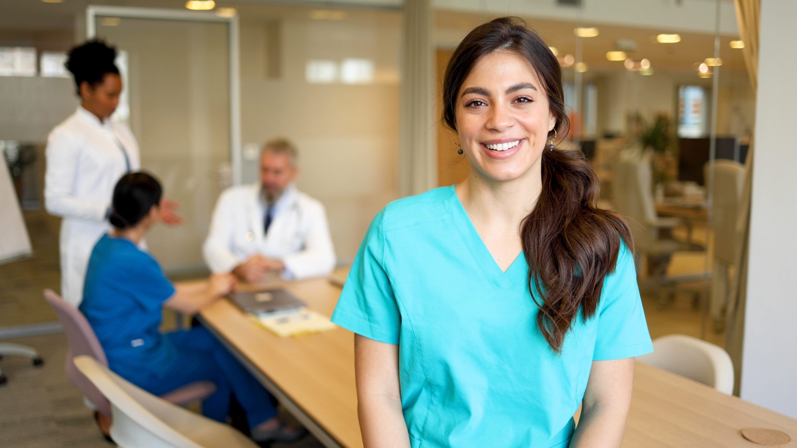 Portrait,Of,A,Smiling,Young,Nurse,Attending,A,Medical,Team