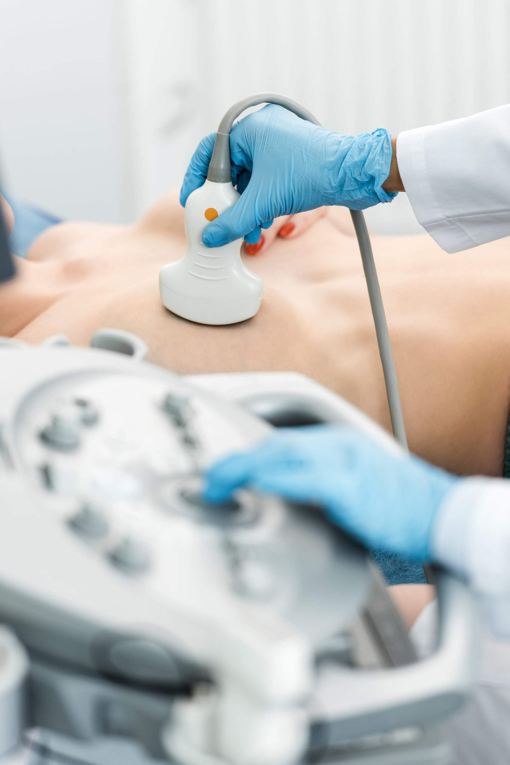 partial view of doctor making breast examination for patient using ultrasound scanner in clinic